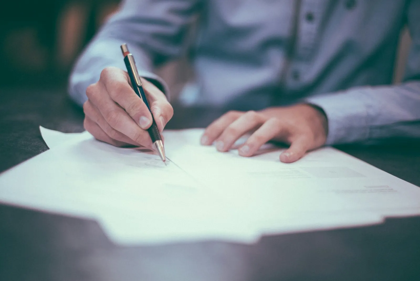 Hands holding insurance and paperwork at a desk